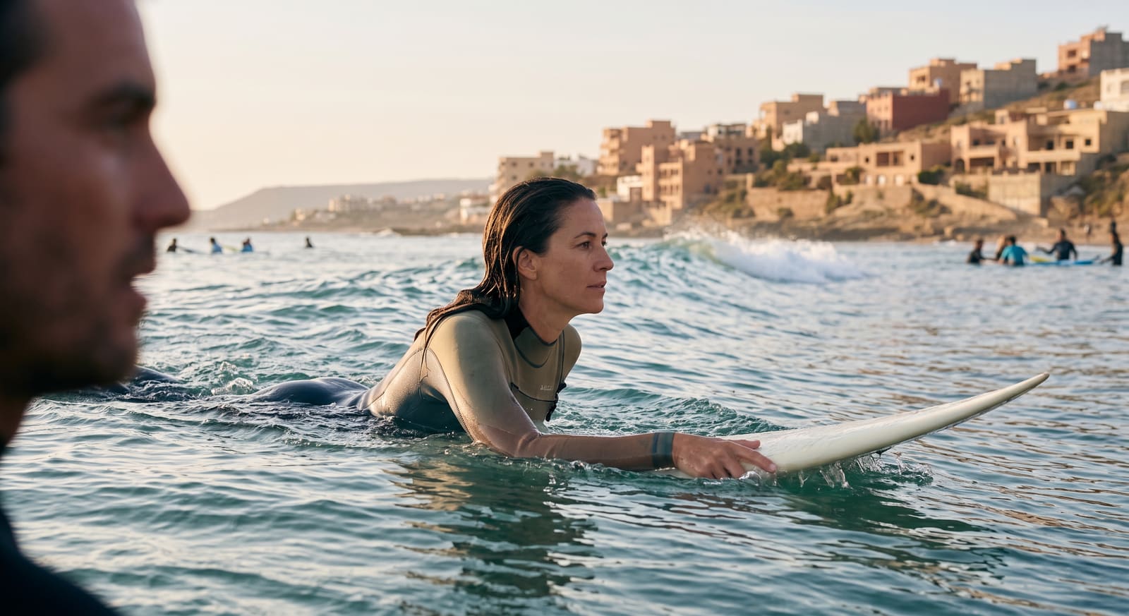 A group of beginner surfers paddling out at Taghazout, Morocco, the kind of restorative surf trip Teefun helps plan and pace.